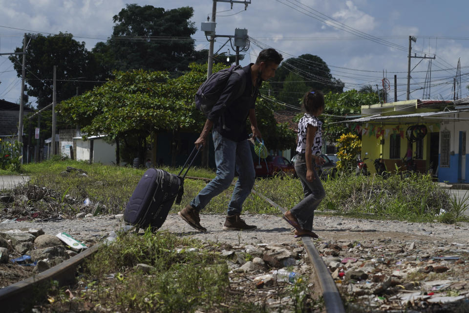 Migrants who are part of caravan cross a railroad track in Huixtla, Chiapas state, Mexico, Tuesday, Oct. 26, 2021, on a day of rest before continuing their trek across southern Mexico to the U.S. border. (AP Photo/Marco Ugarte)