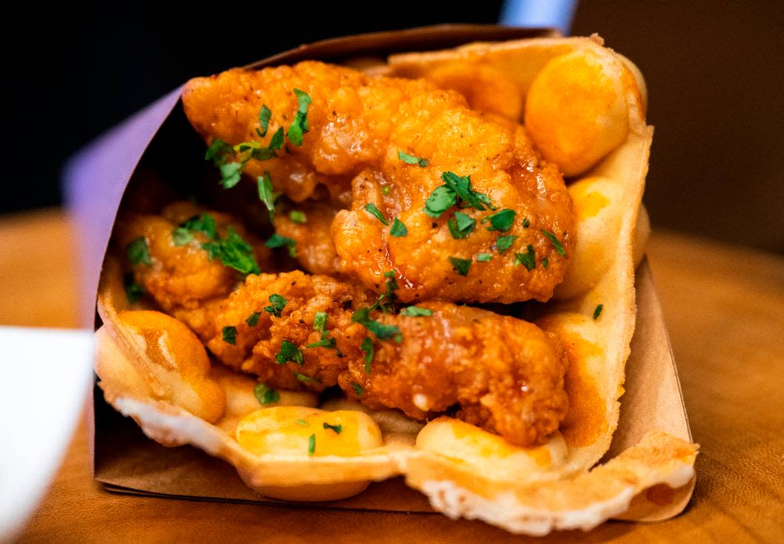 It’s a new world: Spicy chicken is served in a freshly made bubble waffle, a Hong Kong invention, at Seattle’s new hockey arena.