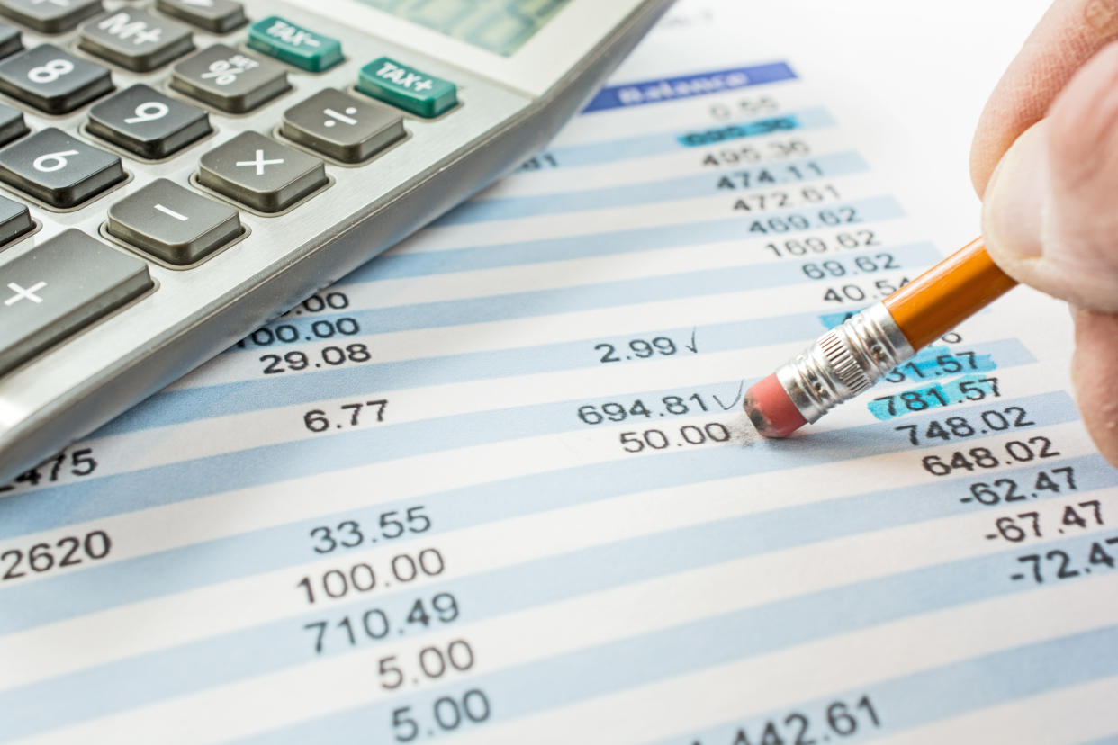 Balancing a bank statement close-up with pencil and calculator