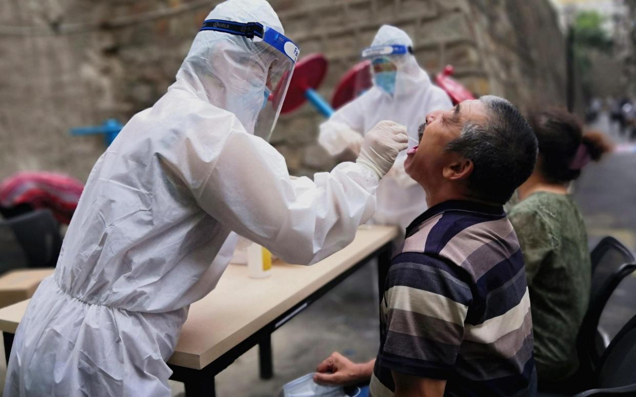 A medical worker swabs the throat of a citizen for a nucleic acid testing during the COVID-19 epidemic on July 19, 2020 in Urumqi - China News Service/China News Service