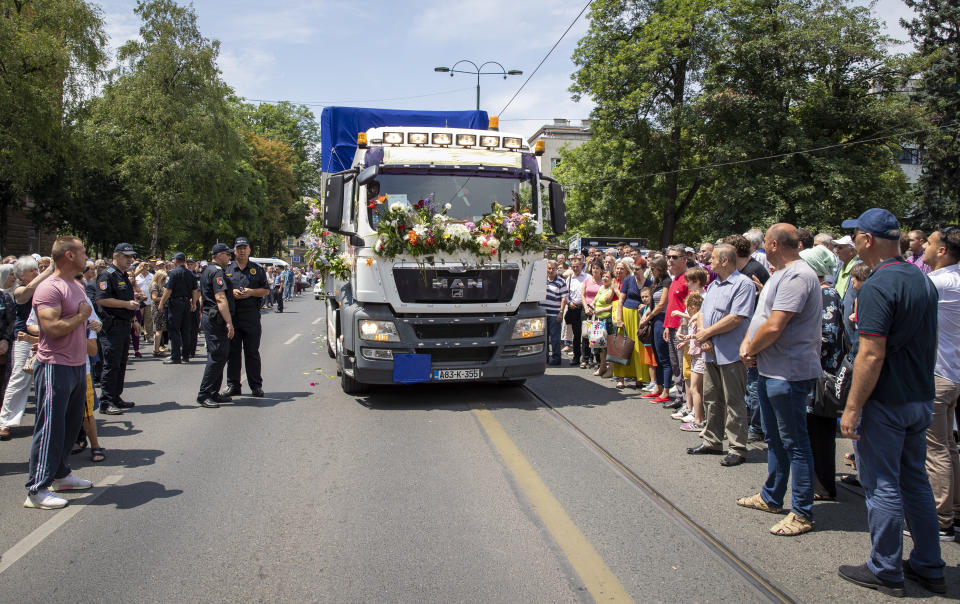 The vehicle carrying the remains of 33 victims of the Srebrenica massacre travels through a street in Sarajevo, Bosnia, Tuesday, July 9, 2019. The remains will be buried in Potocari near Srebrenica, on July 11, 2019, 24 years after Serb troops overran the eastern Bosnian Muslim enclave of Srebrenica and executed some 8,000 Muslim men and boys, which international courts have labeled as an act of genocide. (AP Photo/Darko Bandic)