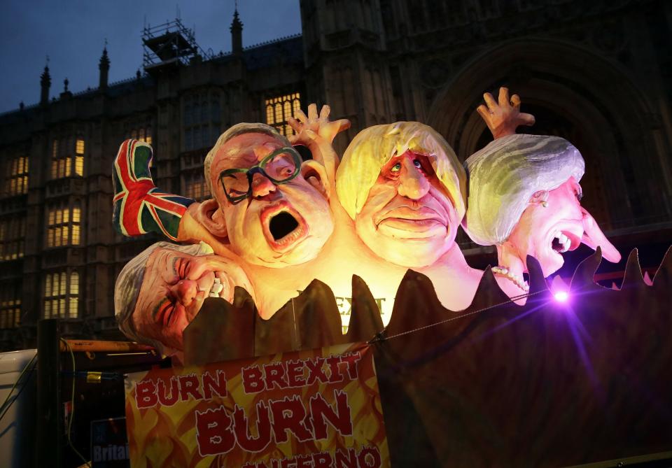 Effigies of British politicians from right, Prime Minister Theresa May, Boris Johnson and Michael Give are driven on a truck by anti-Brexit, remain in the European Union supporters outside the House of Parliament in London, Wednesday, March 13, 2019. Britain's Parliament will vote later Wednesday on whether to rule out leaving the EU on March 29 without a deal. (AP Photo/Tim Ireland)