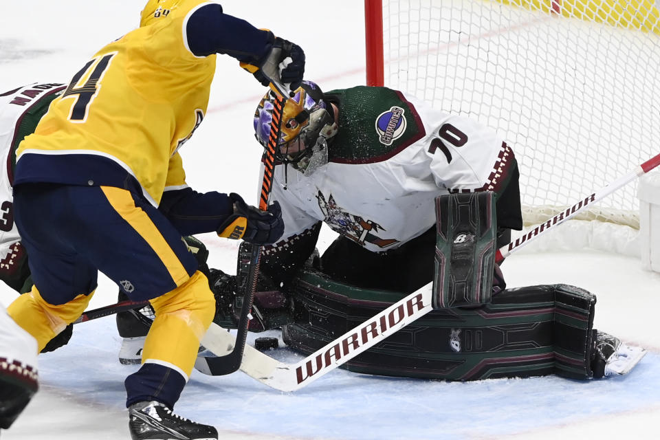 Arizona Coyotes goaltender Karel Vejmelka (70) covers the puck after a shot by the Nashville Predators during the third period of an NHL hockey game Monday, Feb. 13, 2023, in Nashville, Tenn. (AP Photo/Mark Zaleski)