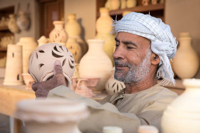 <p>Getty Images</p> An Omani potter shows off his work.