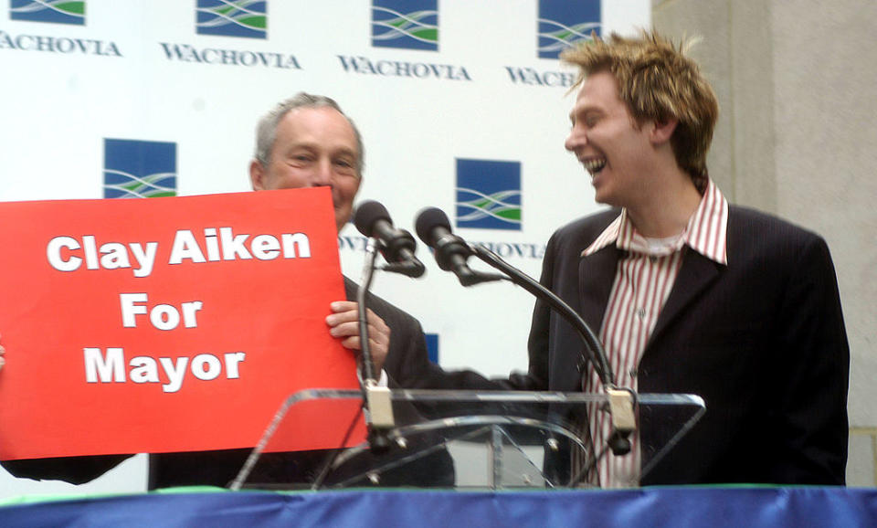 Michael is holding up a "Clay Aiken for Mayor" sign as Clay smiles