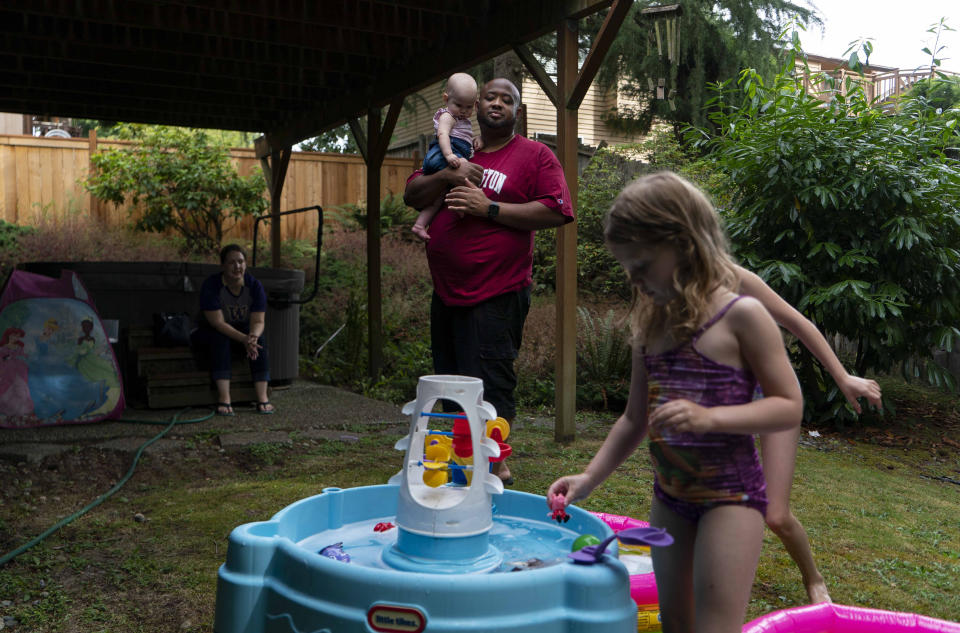 Janae Sturgeon, sentada, y Demetrus Dugar en casa con sus hijos Xayvion, de 9 meses, Hannah, de 7 años, parcialmente oculta, e Isabel, de 3, en Kent, Washington, el 16 de agosto de 2020. (Ruth Fremson/The New York Times)