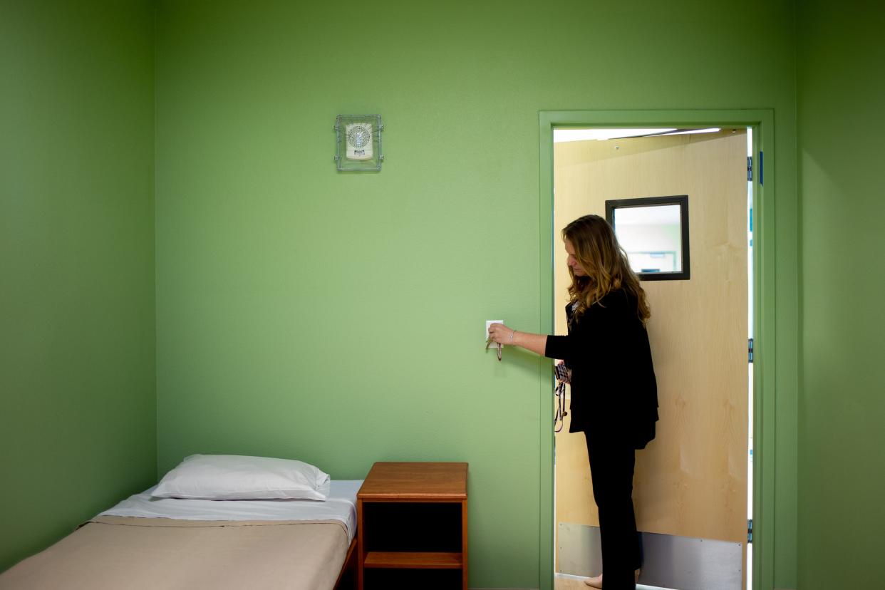 This February 2020 file photo shows Site Director Teresa Hoffmeyer turns on the light in a guest room at RI International, a behavioral health center in Peoria, Arizona.