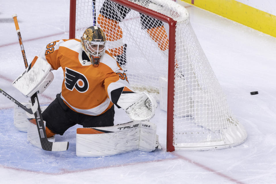 Philadelphia Flyers goaltender Felix Sandstrom (32) deflects a shot on goal by San Jose Sharks left wing Evgeny Svechnikov during the first period of an NHL hockey game, Sunday, Oct. 23, 2022, in Philadelphia. (AP Photo/Laurence Kesterson)
