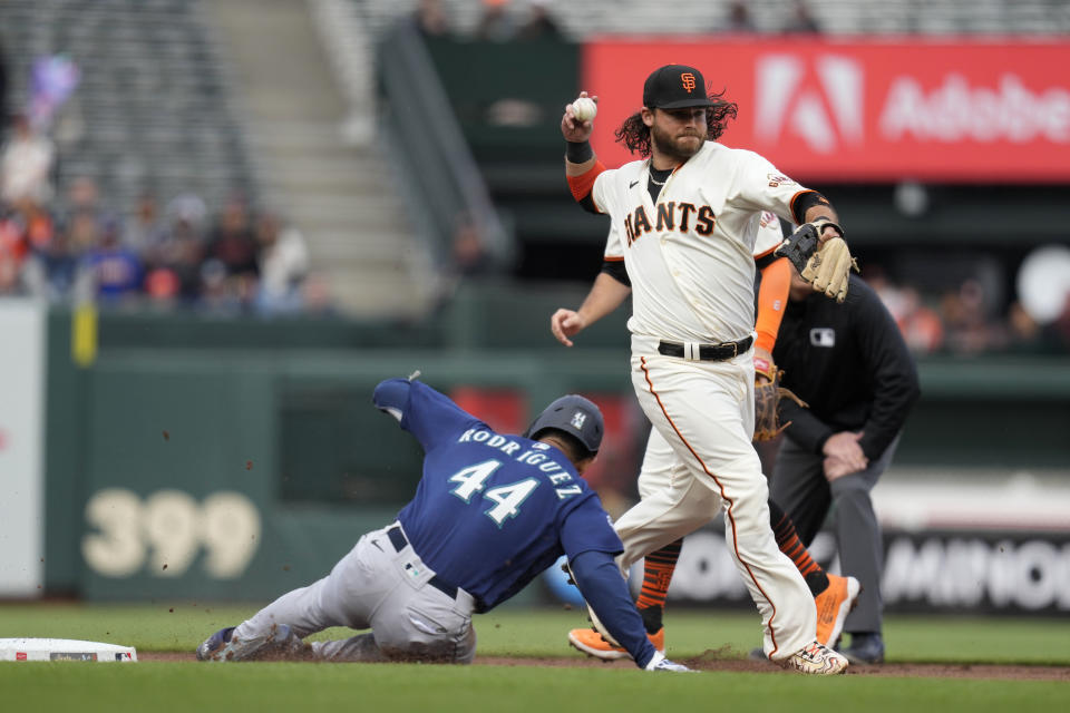 San Francisco Giants shortstop Brandon Crawford turns a double play as the Seattle Mariners' Julio Rodriguez (44) is forced out at second base in the first inning of a baseball game in San Francisco, Wednesday, July 5, 2023. The Mariners' Teoscar Hernandez was out at first base on the play. (AP Photo/Eric Risberg)