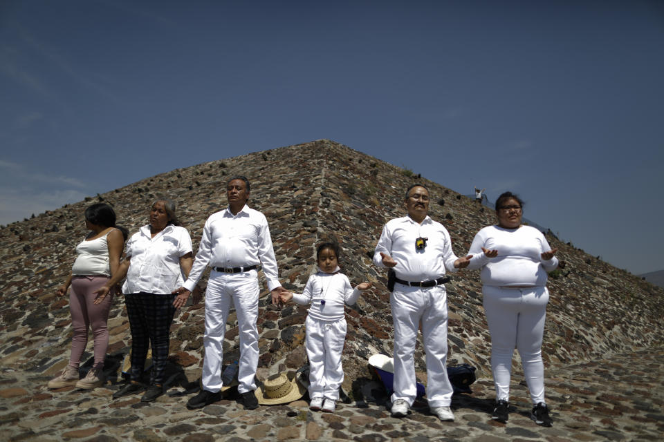 The Martinez family from Puebla celebrates the Spring equinox a little early, to avoid crowds and closures, atop the Pyramid of the Sun, in Teotihuacan, Mexico, Thursday, March 19, 2020. To slow the spread of the new coronavirus, authorities announced Wednesday that they would close the pyramid complex on weekends, beginning Saturday, March 21, when thousands of visitors typically climb the Pyramid of the Sun to celebrate the Spring equinox.(AP Photo/Rebecca Blackwell)
