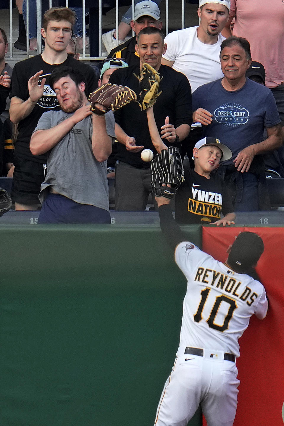 A home-run ball hit by New York Mets' Francisco Lindor lands in the stands out of the reach of Pittsburgh Pirates left fielder Bryan Reynolds (10) during the third inning of a baseball game in Pittsburgh, Friday, June 9, 2023. (AP Photo/Gene J. Puskar)
