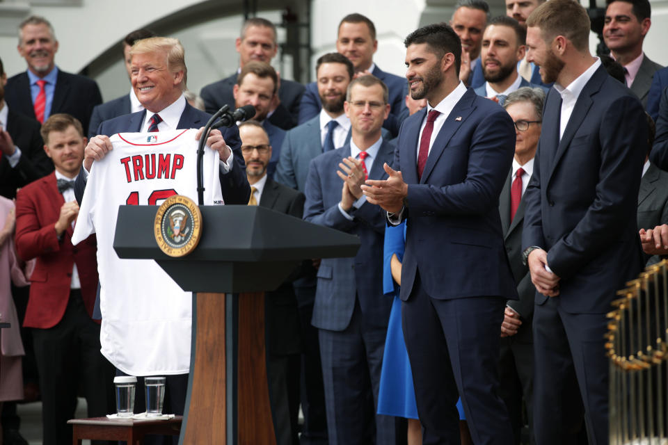 U.S. President Donald Trump is presented with a jersey as right fielder J.D. Martinez and pitch Chris Sales look on during a South Lawn event to honor the Boston Red Sox at the White House May 9, 2019 in Washington, DC. President Donald Trump hosted the Boston Red Sox to honor their championship of the 2018 World Series.(Photo by Alex Wong/Getty Images)