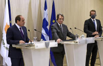 Cyprus President Nicos Anastasiades, center, Greece's Prime minister Kyriakos Mitsotakis, right, and Egypt's President Abdel-Fattah el-Sissi talk to the media during a press conference after their meeting at the presidential palace in capital Nicosia, Cyprus, on Wednesday, Oct. 21, 2020. The leaders of Cyprus, Egypt and Greece meet in the Cypriot capital for talks on forging closer ties and boosting cooperation on issues including energy following the discovery of gas deposits in the east Mediterranean. (Iakovos Hatzistavrou Pool via AP)