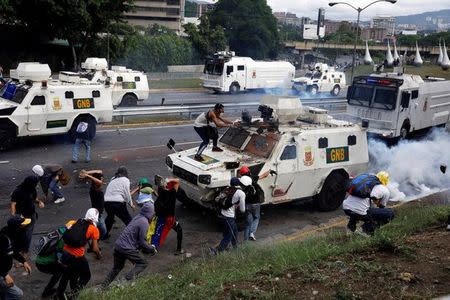 Demonstrators clash with riot police on armored car during rally against Venezuela's President Nicolas Maduro in Caracas, Venezuela May 1, 2017. REUTERS/Carlos Garcia Rawlins