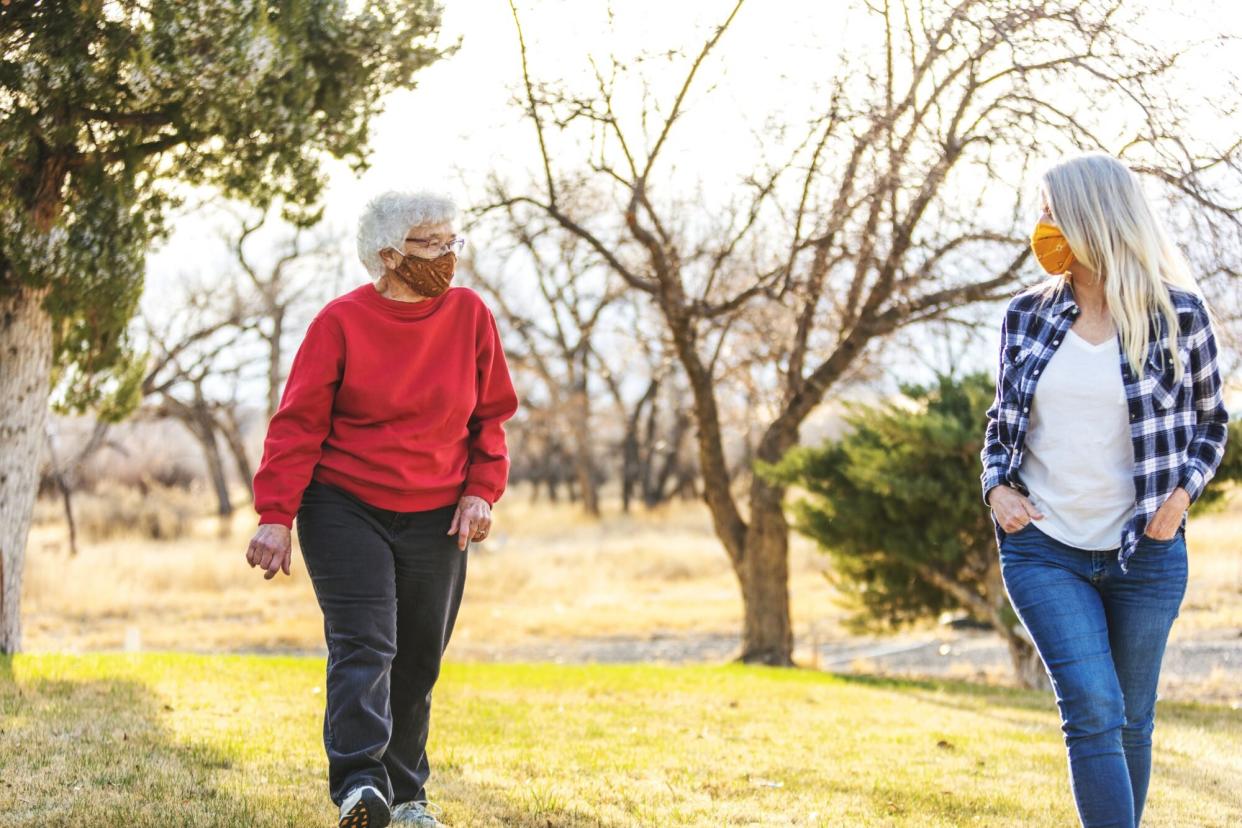 masked women on a socially-distanced walk together