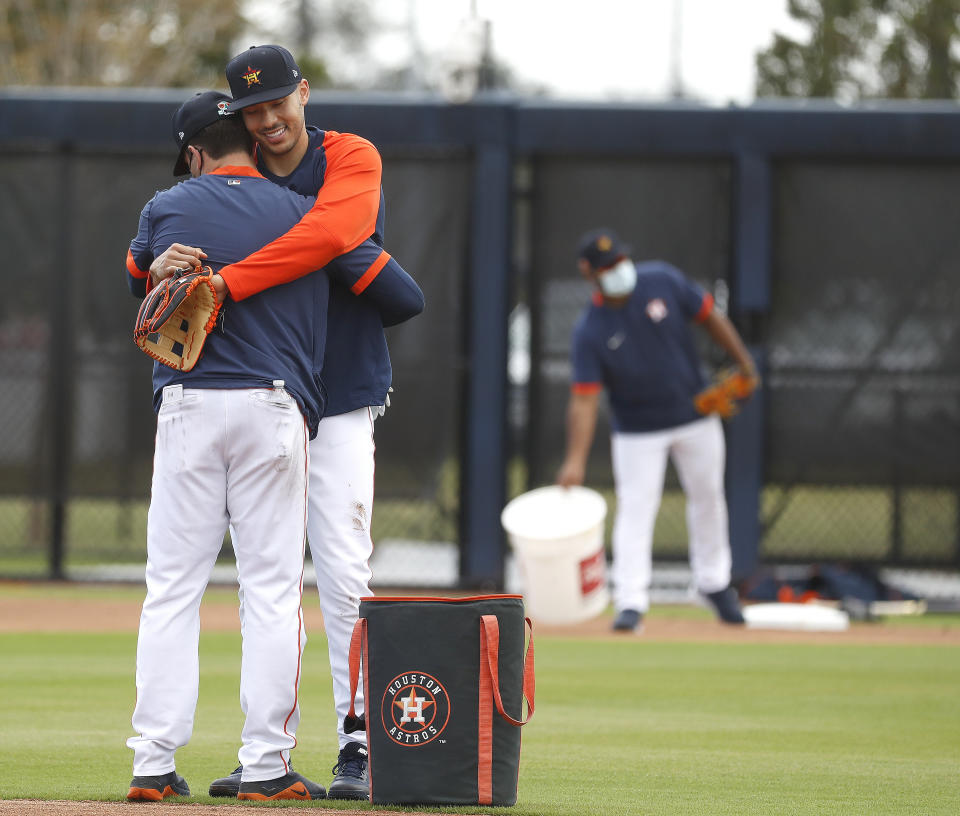 Houston Astros shortstop Carlos Correa gives hitting coach Troy Snitker a hug during spring training baseball in West Palm Beach, Fla., Monday, Feb. 22, 2021. (Karen Warren/Houston Chronicle via AP)