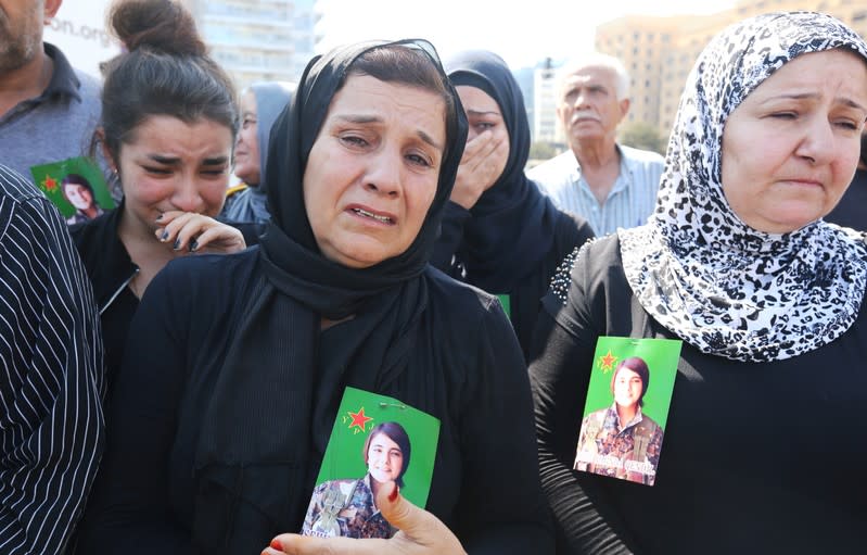 A Kurdish woman living in Lebanon, who has a picture of Hevrin Khalaf placed on her chest, reacts during a protest against Turkey's military action in northeastern Syria, in Beirut