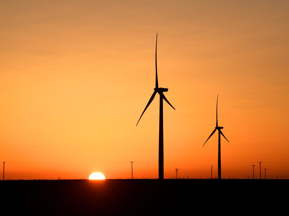 Wind turbines pictured at sunset.