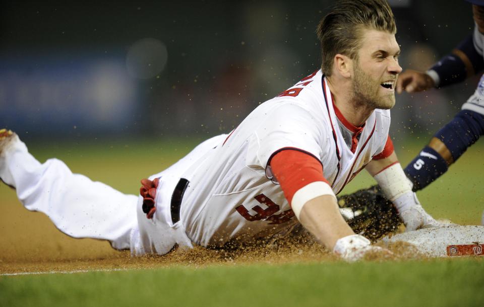 Washington Nationals left fielder Bryce Harper slides into third with a three RBI triple during the third inning of a baseball game against the San Diego Padres, Friday, April 25, 2014, in Washington. (AP Photo/Nick Wass)
