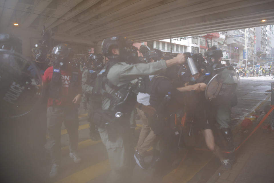 Riot Police use pepper spray to protesters during a protest against Beijing's national security legislation in Causeway Bay in Hong Kong, Sunday, May 24, 2020. Hong Kong police fired volleys of tear gas in a popular shopping district as hundreds took to the streets Sunday to march against China's proposed tough national security legislation for the city. (AP Photo/Kin Cheung)