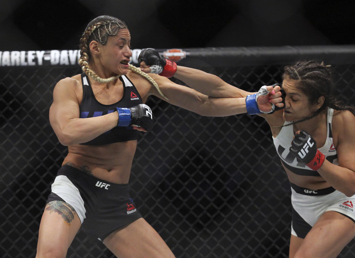 Pearl Gonzalez lanza un puñetazo a Cynthia Calvillo durante el combate de artes marciales mixtas de la UFC210 que estuvo a punto de ser cancelado a causa de sus implantes de silicona, en Abril de 2017, Buffalo, Nueva York. (AP Photo/Jeffrey T. Barnes)