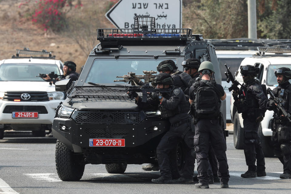 Israeli security stand in position on a road following a mass infiltration by Hamas gunmen from the Gaza Strip, near Sderot in southern Israel October 8, 2023. (PHOTO:REUTERS/Ronen Zvulun)