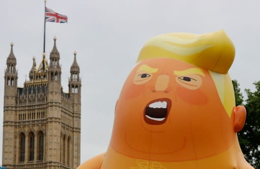 A giant balloon depicting US President Donald Trump as an orange baby floats above anti-Trump demonstrators in Parliament Square in London