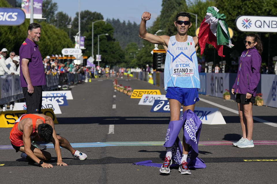 El japonés Masatora Kawano se desploma junto al italiano Massimo Stano, quien lo superó para llevarse el oro en los 35 kilómetros de marcha, el domingo 24 de julio de 2022, en el Mundial de Atletismo en Eugene, Oregon (AP Foto/Gregory Bull)