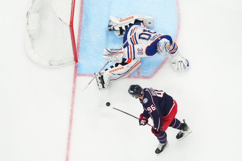 Mar 7, 2024; Columbus, Ohio, USA; Columbus Blue Jackets center Jack Roslovic (96) shoots at Edmonton Oilers right wing Corey Perry (90) during the NHL hockey game at Nationwide Arena. The Blue Jackets won 4-2.