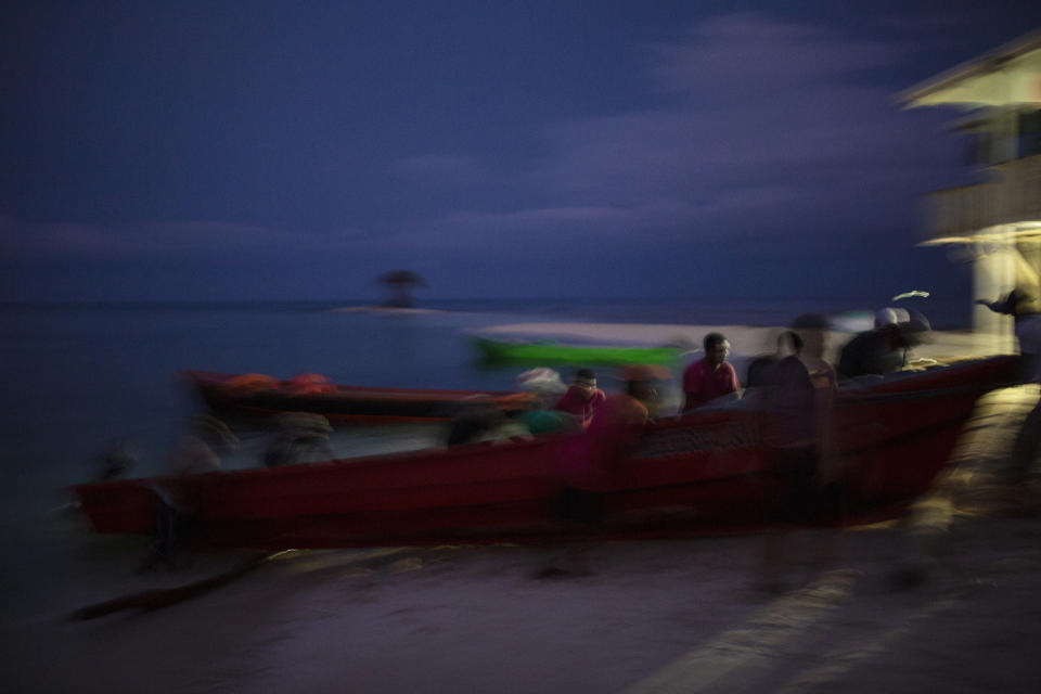 En esta fotografía del 10 de septiembre de 2018, pescadores misquitos empujan un bote a la costa en Cayo Savanna, Honduras. Miles de hombres han hecho de la pesca por buceo su forma de vida en la Mosquitia, una región de Honduras y Nicaragua enclavada en la costa caribe. (AP Foto/Rodrigo Abd)