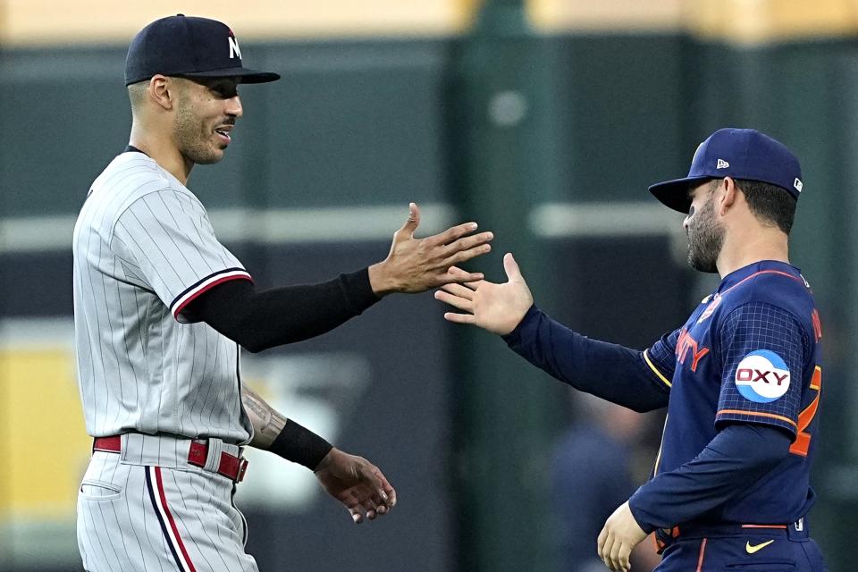 Minnesota Twins' Carlos Correa, left, shakes hands with Houston Astros' Jose Altuve before a baseball game Monday, May 29, 2023, in Houston. (AP Photo/David J. Phillip)