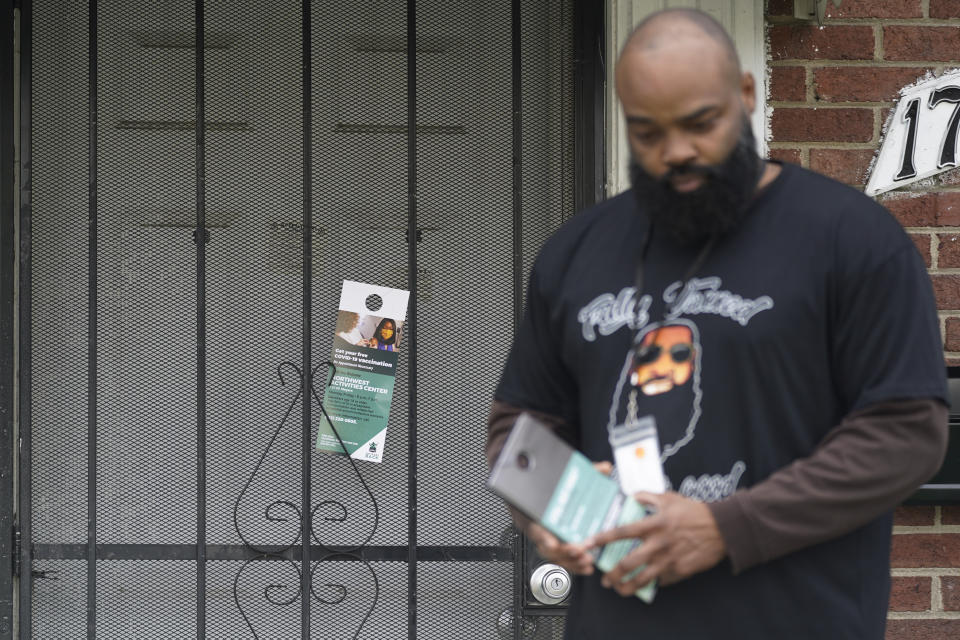 Anthony Brinson leaves a flyer on a home in Detroit, Tuesday, May 4, 2021. Officials are walking door-to-door to encourage residents of the majority Black city to get vaccinated against COVID-19 as the city's immunization rate lags well behind the rest of Michigan and the United States. (AP Photo/Paul Sancya)