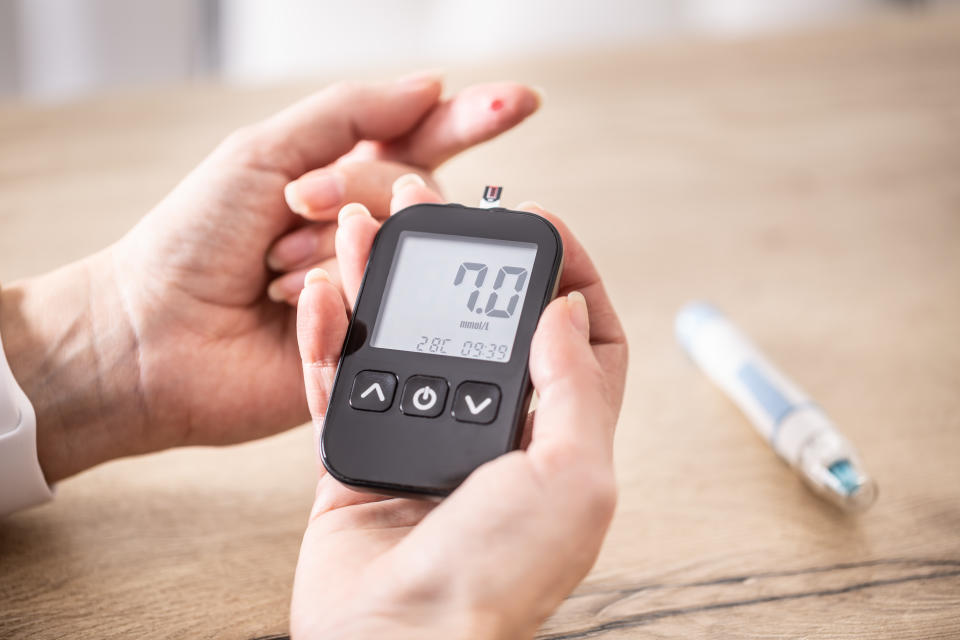 Close-up of woman hands measuring glucose level blood test  for diabetes with glucometer.