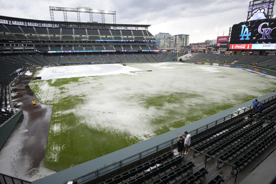 A mixture of rain and hail covers the outfield after a summer storm Thursday, June 29, 2023, in Denver. The Colorado Rockies were scheduled to play against the Los Angeles Dodgers. (AP Photo/David Zalubowski)