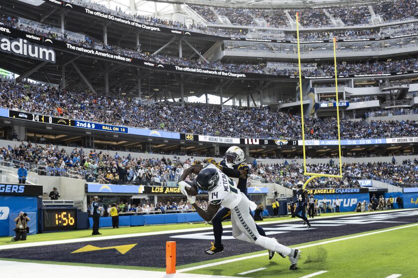 Seattle Seahawks wide receiver DK Metcalf (14) catches a pass over Los Angeles Chargers cornerback J.C. Jackson (27) during an NFL football game, Sunday, Oct. 23, 2022, in Inglewood, Calif. (AP Photo/Kyusung Gong)