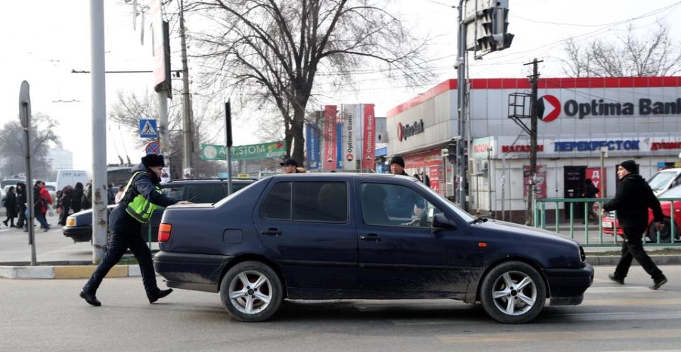  A policeman regulates traffic during a power outage in Bishkek, Kyrgyzstan, on 25 January 2022 (EPA)