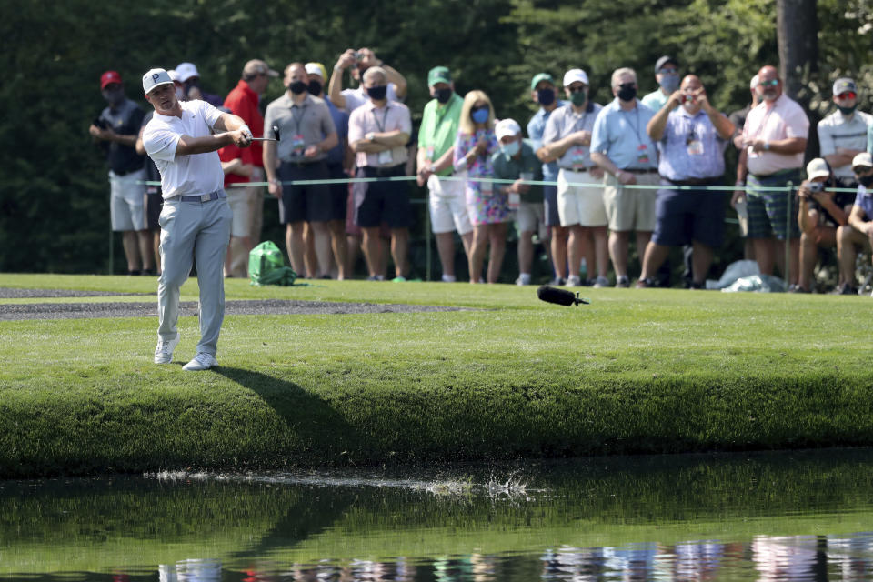 Patrons watches as Bryson DeChambeau skip his ball across the pond to the 16th green during a practice round for the Masters golf tournament at Augusta National Golf Club on Wednesday, April 7, 2021, in Augusta, Ga. (Curtis Compton/Atlanta Journal-Constitution via AP)