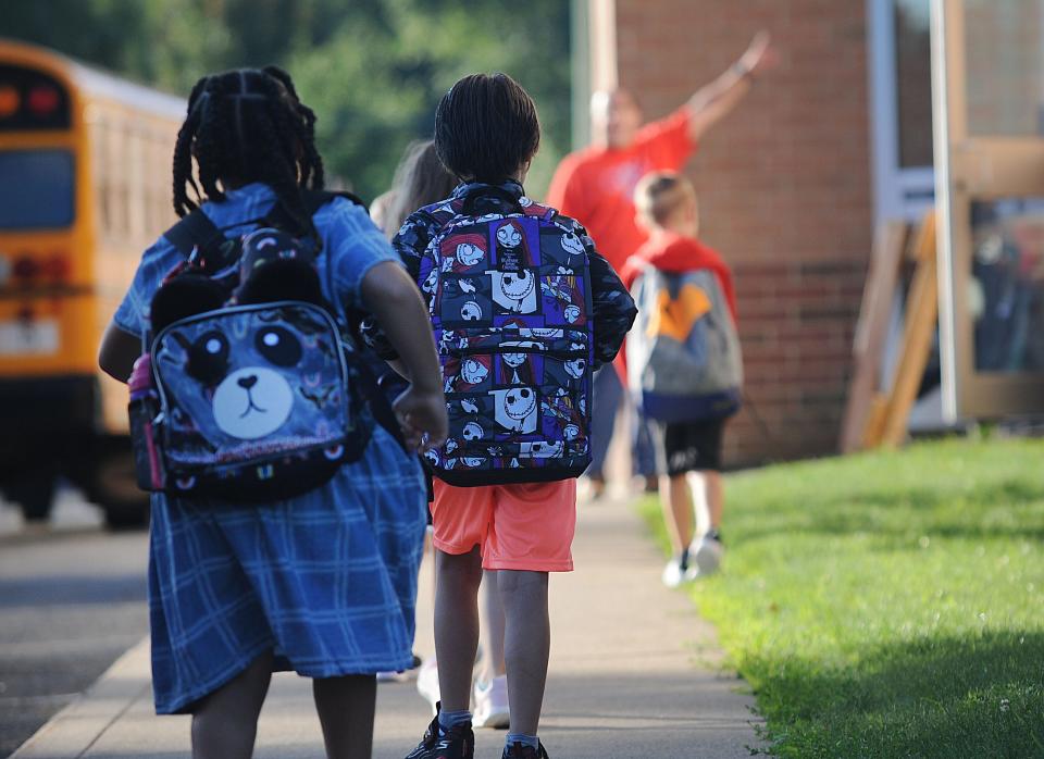 An Alliance Elementary School staff member directs children as they arrive Thursday, Aug. 18, 2022, for the first day of classes. Students in the district have staggered starting days at the beginning of the 2022-23 school year.