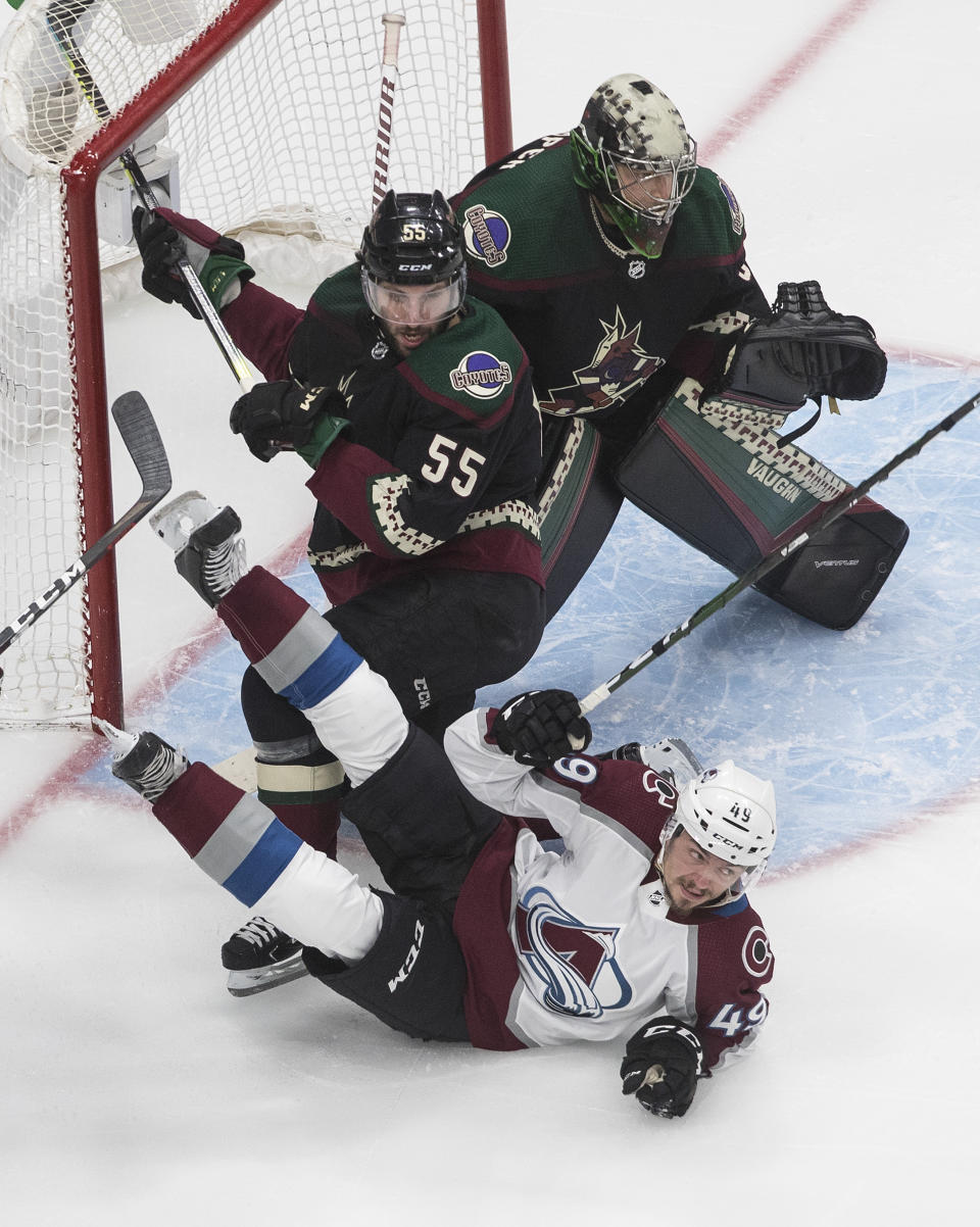 Colorado Avalanche's Samuel Girard (49) is checked by Arizona Coyotes' Jason Demers (55) as goalie Darcy Kuemper (35) looks for the shot during the first period in Game 4 of an NHL hockey first-round playoff series in Edmonton, Alberta, Monday, Aug. 17, 2020. (Jason Franson/The Canadian Press via AP)