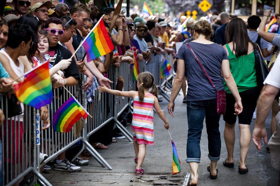 A girl high fives a reveler as she marches in the New York City Gay Pride march on June 24, 2012 in New York City. The annual civil rights demonstration commemorates the Stonewall riots of 1969, which erupted after a police raid on a gay bar, the Stonewall Inn on Christopher Street. (Photo by Michael Nagle/Getty Images)