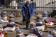 FILE - A man stands among piles of humanitarian food supplies in Kabul, Afghanistan, Wednesday, Feb. 16, 2022. Some 1.6 billion people in 94 countries face at least one dimension of the crisis in food, energy and financial systems, according to a report last month by the Global Crisis Response Group of the United Nations Secretary-General. (AP Photo/Hussein Malla, File)