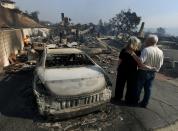 <p>Michael and Vonea McQuillam stand beside their house that was burnt to the ground during the Thomas wildfire in Ventura, Calif., on Dec. 5, 2017. (Photo: Mark Ralston/AFP/Getty Images) </p>