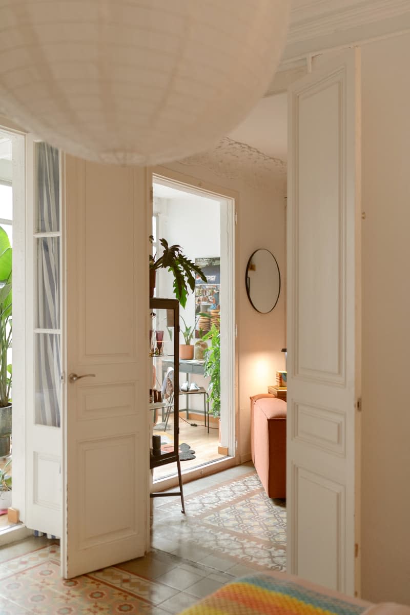 Tall French doors separate white rooms.