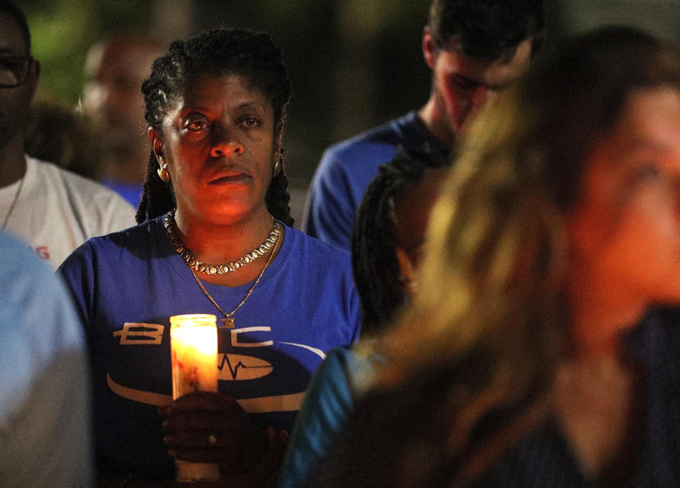 A woman holds a candle during a candlelight vigil for Miya Marcano at Arden Villas, Friday, Oct. 1, 2021, in Orlando, Fla., outside the Valencia College student's apartment. Orange County Sheriff John Mina said Saturday that authorities found Miya Marcano’s body near an apartment building. Marcano vanished on the same day a maintenance man improperly used a master key to enter her apartment. (Chasity Maynard/Orlando Sentinel via AP)