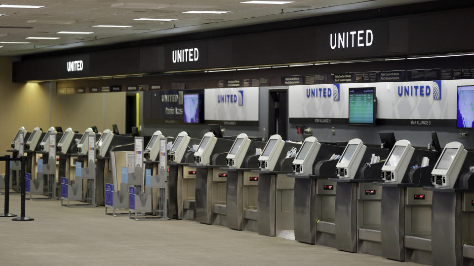 Empty United Airlines ticket machines are shown at the Tampa International Airport Friday, April 24, 2020, in Tampa, Fla. Business at the airport has been at a near standstill due to the coronavirus outbreak. (AP Photo/Chris O'Meara)