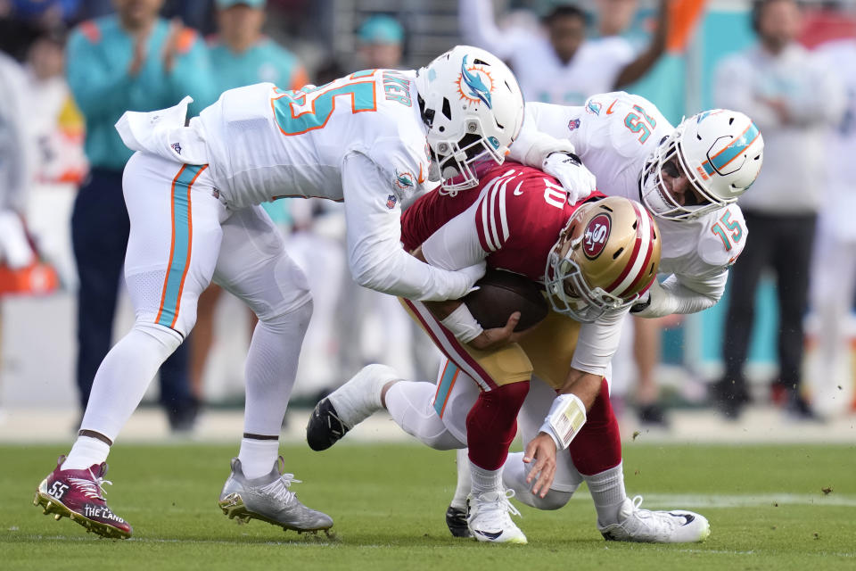 San Francisco 49ers quarterback Jimmy Garoppolo, middle, is sacked by Miami Dolphins linebacker Jerome Baker, left, and linebacker Jaelan Phillips (15) during the first half of an NFL football game in Santa Clara, Calif., Sunday, Dec. 4, 2022. (AP Photo/Godofredo A. Vásquez)