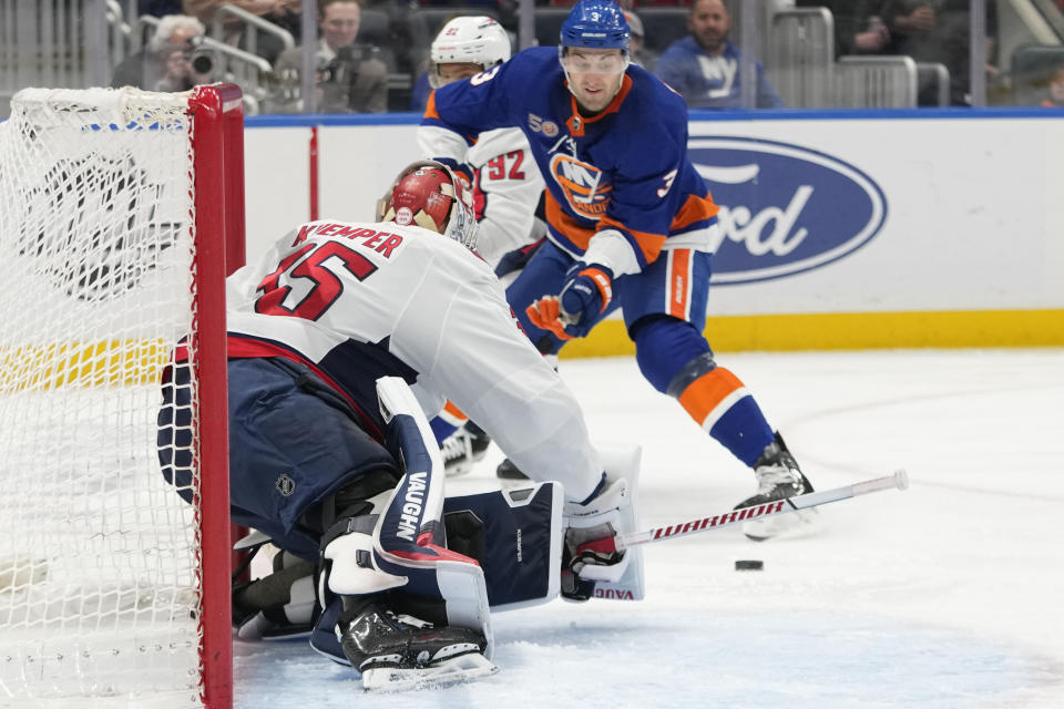 Washington Capitals goaltender Darcy Kuemper (35) makes a save against New York Islanders defenseman Adam Pelech (3) during the second period of an NHL hockey game Saturday, March 11, 2023, in Elmont, N.Y. (AP Photo/Mary Altaffer)