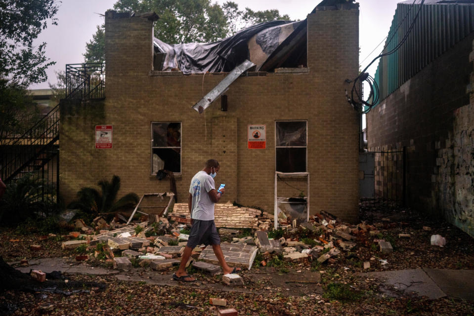 Joel Martinez takes a photo of Washington Gardens Apartments after it collapsed from the winds brought by Hurricane Zeta in New Orleans on October 28, 2020. / Credit: Reuters/Kathleen Flynn