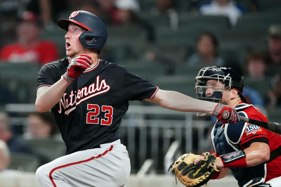 Washington Nationals' Erick Fedde (23) drives in a run with a sacrifice fly as Atlanta Braves catcher Stephen Vogt, right, looks on in the fifth inning of a baseball game Friday, Aug. 6, 2021, in Atlanta. (AP Photo/John Bazemore)