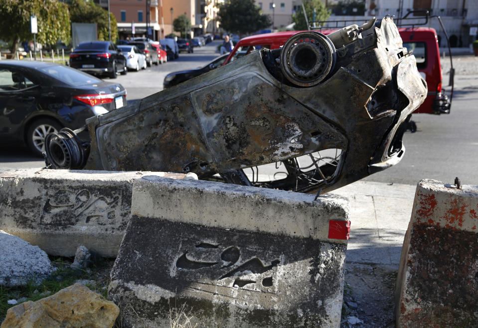 A burned car that was set on fire early Tuesday by supporters of the Shiite Hezbollah and Amal Movement groups, lies on a roadside, in Beirut, Lebanon, Tuesday, Dec. 17, 2019. Supporters of Lebanon's two main Shiite groups Hezbollah and Amal clashed with security forces and set fires to cars in the capital early Tuesday, apparently angered by a video circulating online that showed a man insulting Shiite figures. (AP Photo/Hussein Malla)